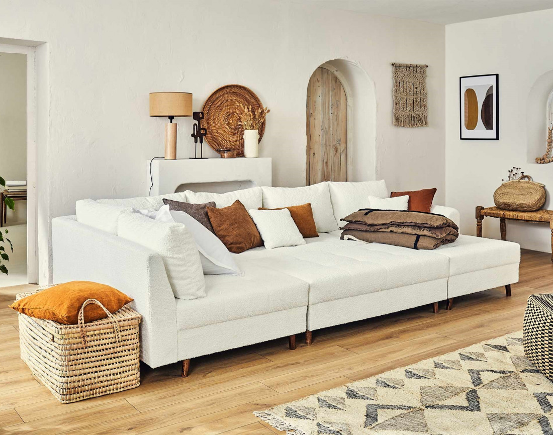 Canapé panoramique d'angle gauche 7 places avec pouf d'appoint en tissu bouclette Rune